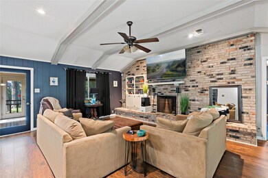 Living room featuring brick wall, wood-type floori