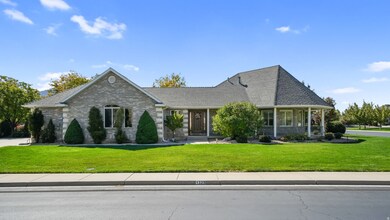 View of front of property with a front lawn, brick siding, covered porch, and a shingled roof