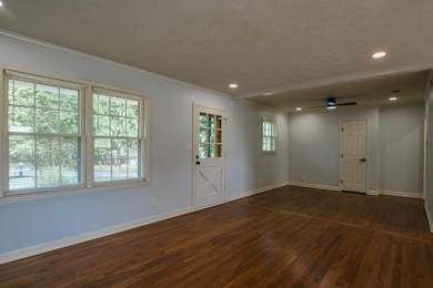 Foyer with dark wood-type flooring, a textured ceiling, ornamental molding, ceiling fan, and recessed lighting