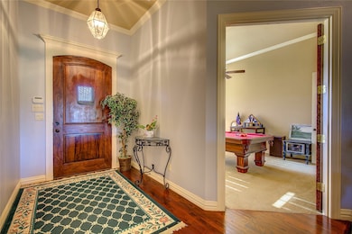 Entryway featuring crown molding, pool table, and hardwood floors entry.