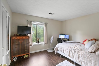 Bedroom featuring wood-type flooring and a textured ceiling