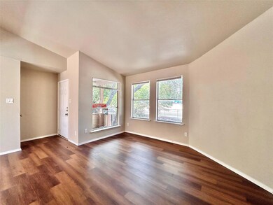 Unfurnished living room featuring dark wood-style floors and lofted ceiling