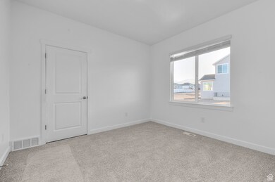 Unfurnished room featuring baseboards and light carpet