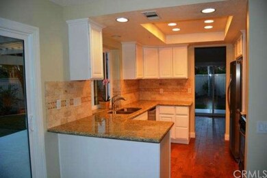 Kitchen with granite, white cabinets and hardwood 