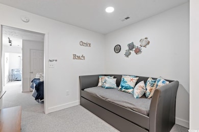 Living area with carpet flooring and baseboards