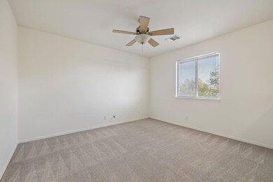 Carpeted empty room featuring ceiling fan and bas