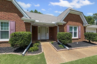 Property entrance featuring a shingled roof and brick siding