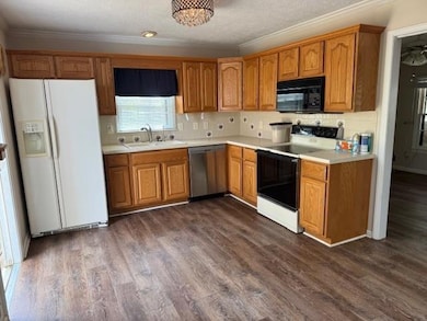 Kitchen featuring a sink, black microwave, white r