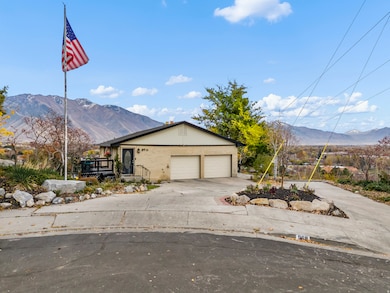 View of front facade featuring a mountain view, concrete driveway, brick siding, and a garage