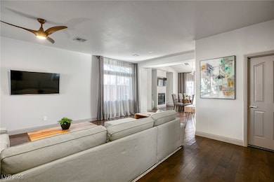Living area with a ceiling fan, baseboards, and da