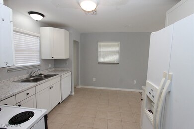 Kitchen with white appliances, light stone counter