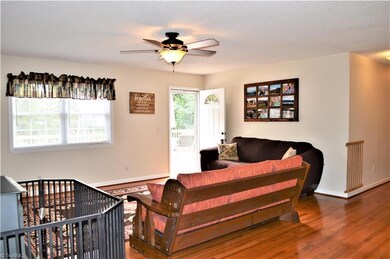 Living Room:  Wood Flooring, Ceiling Fan, Exterior Door leads to Large Deck, Wood Burning Wood-stove