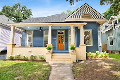 View of front of property featuring covered porch, a shingled roof, and ceiling fan