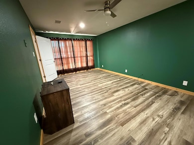 Spare room featuring ceiling fan, wood finished f