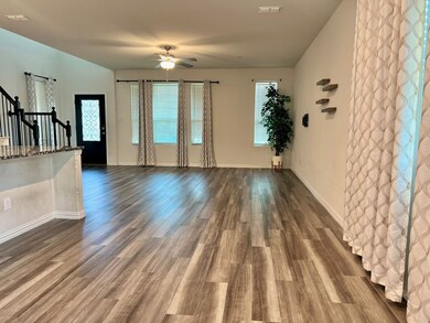 Unfurnished living room featuring stairs, dark wood-style floors, and ceiling fan