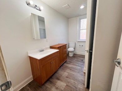 Bathroom with a textured ceiling, vanity, toilet, 