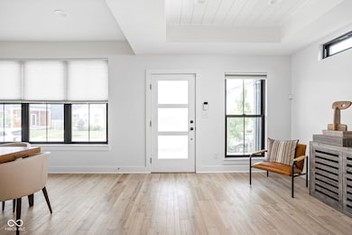 foyer entrance with a raised ceiling and light wood-style floors