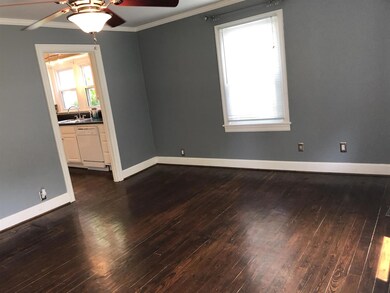 Family room has lots of natural light, hardwood floors and ceiling fan.