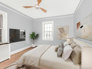 Bedroom with radiator, crown molding, wood finished floors, and ceiling fan