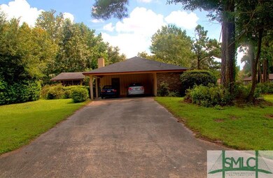 Side house/carport view and driveway entrance.