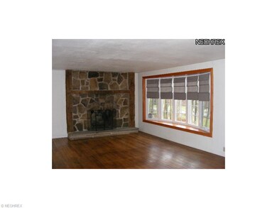 Great room with stone fireplace and bay window.