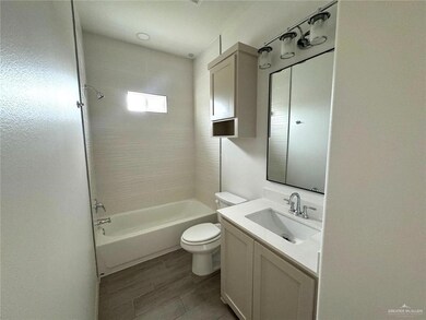 Full bathroom featuring toilet, vanity,  shower combination, and wood tiled floor