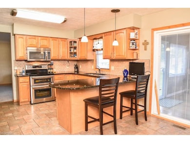 Kitchen has tile backsplash and a breakfast bar.
