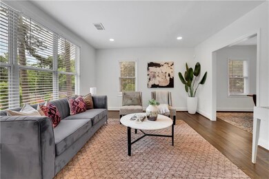Living area with wood finished floors, baseboards, and recessed lighting