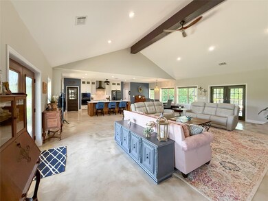 Living room featuring beam ceiling, high vaulted 