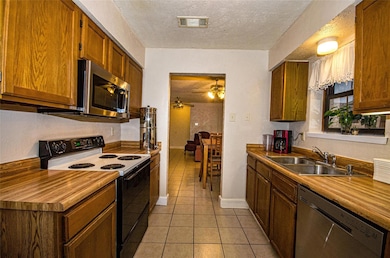 Kitchen featuring ceiling fan, sink, appliances wi