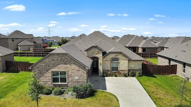 French country inspired facade with stone siding, a residential view, a shingled roof, and brick siding