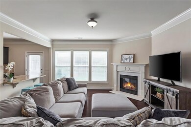 Fireside living room is overlooked by a bank of windows to the private backyard and the stylish open kitchen.
