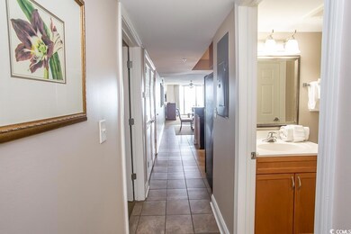 Hallway with light tile patterned flooring and sin
