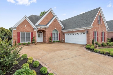 Traditional-style house featuring brick siding, roof with shingles, driveway, and a garage