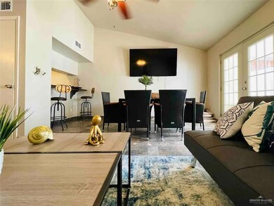 Living room featuring french doors, ceiling fan, vaulted ceiling, and light tile patterned floors