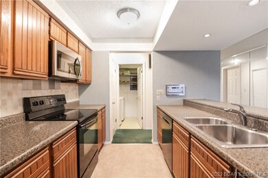 Galley kitchen with new refrigerator and microwave