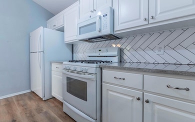 Kitchen featuring white appliances, tasteful back