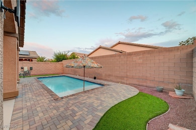 View of swimming pool with a patio and a fenced ba
