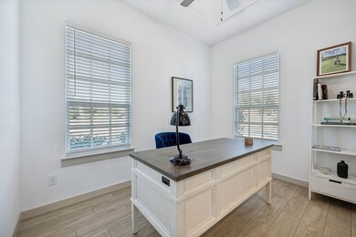 Office with light wood-style flooring and ceiling fan