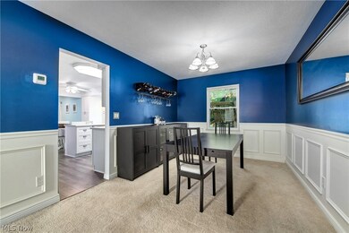 Dining area featuring ceiling fan with notable chandelier and light colored carpet