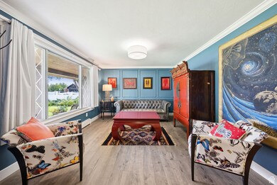 Living area with ornamental molding and wood finished floors