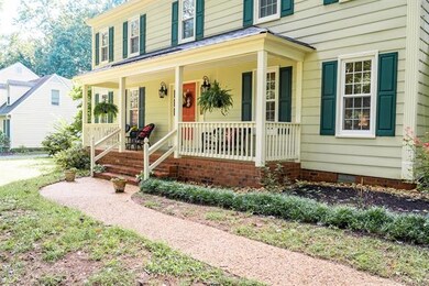 An aggregate walkway leads to the brick front step