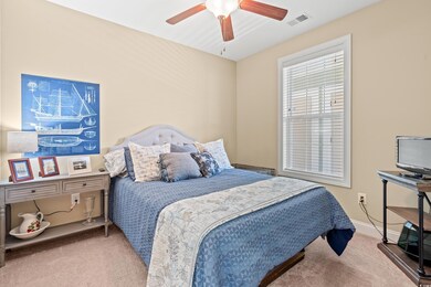Carpeted bedroom featuring ceiling fan and baseboards