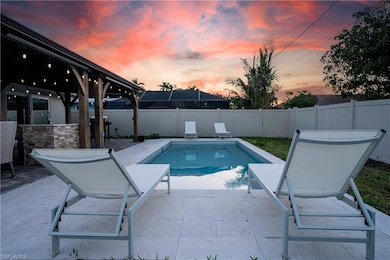 Pool at dusk with a patio and a fenced backyard