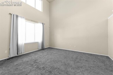 Carpeted empty room with a high ceiling