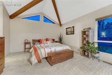 Master bedroom with vaulted and beamed ceilings.
