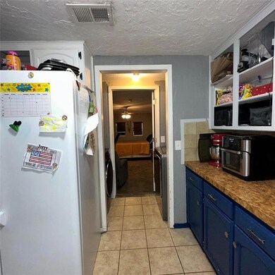 Kitchen with white refrigerator, ceiling fan, blue