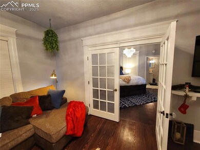 Unit 1 Bedroom with dark wood-style flooring and a chandelier