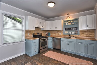 Kitchen has rustic pine floors, tumbled stone back