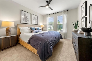 Bedroom featuring light carpet, ceiling fan, and b